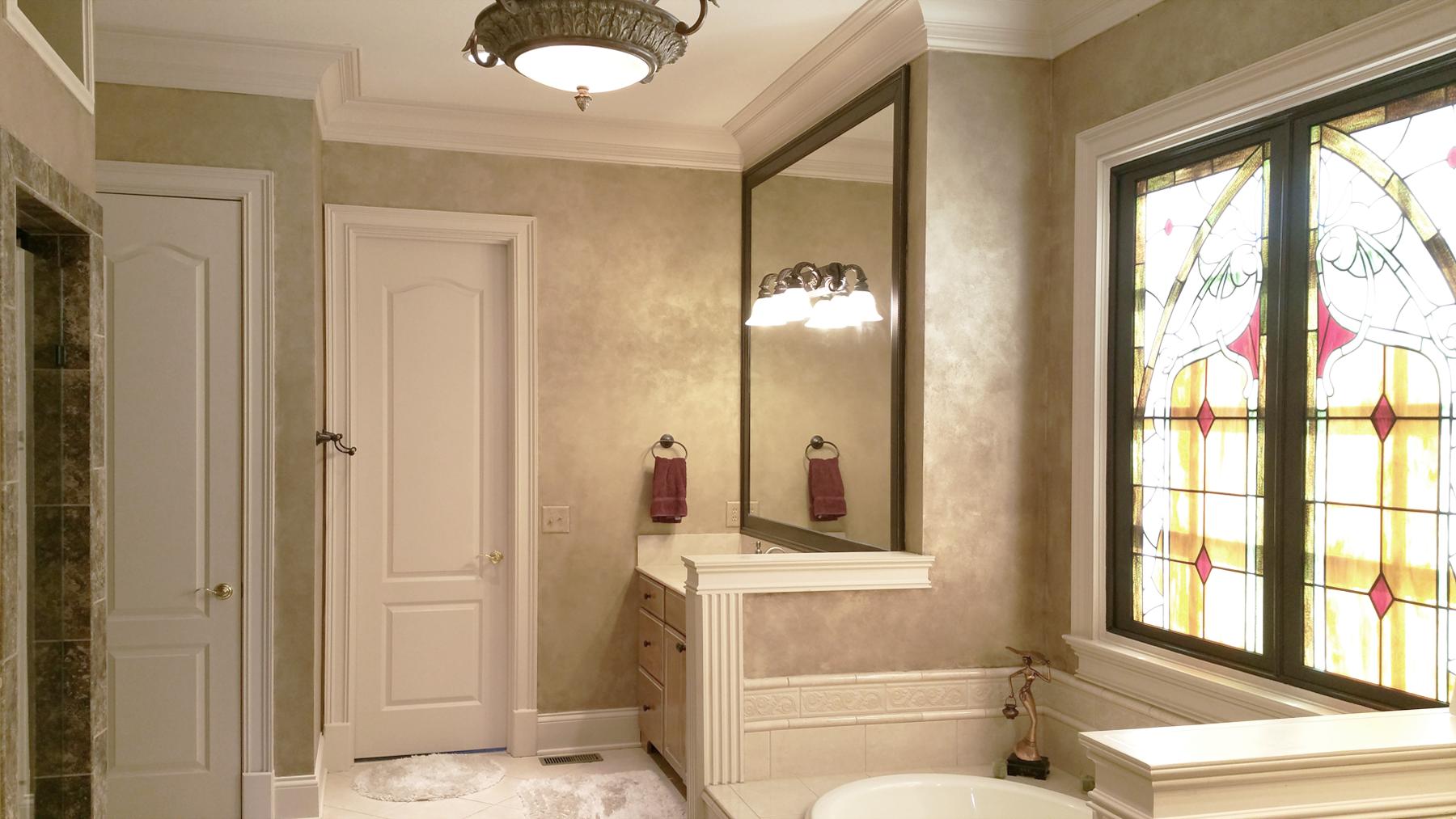Master Bath Shimmering Lusterstone walls with custom faux designed mirror frames.