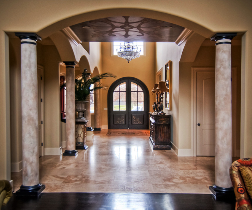 Spanish faux stone columns, bronze caps and custom stone and metal ceiling mural.