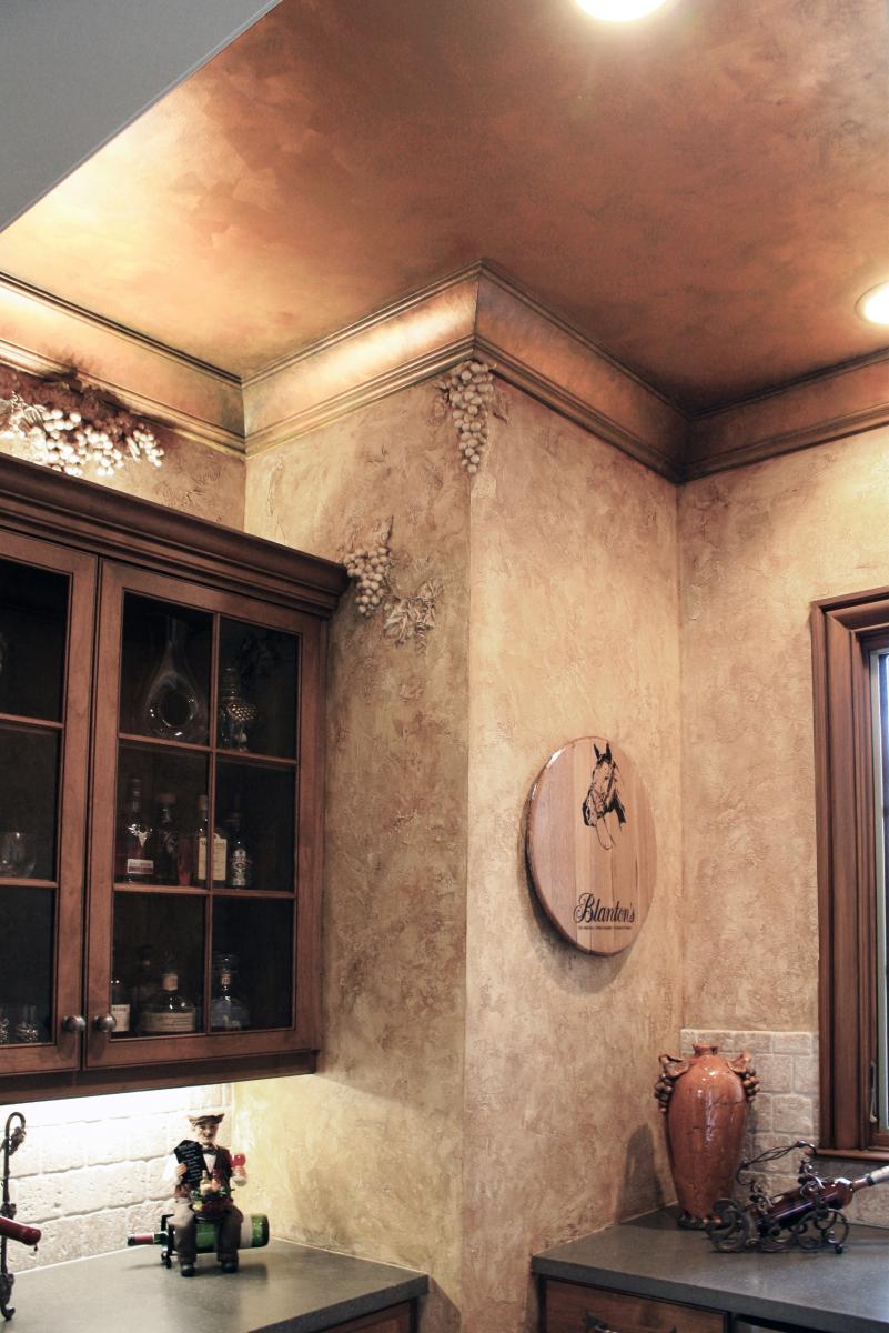 Faux sculpted grapes over European plastered walls in this wine rooms Liquor cabinet on with faux copper ceiling.